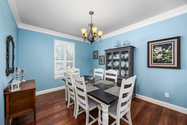 dining space with dark wood-type flooring, an inviting chandelier, and crown molding