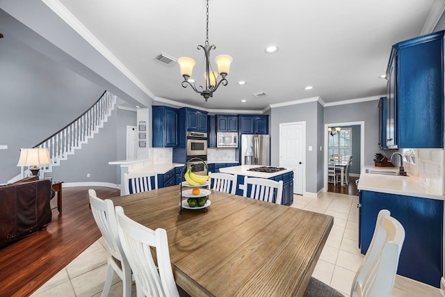 tiled dining space featuring an inviting chandelier, sink, and ornamental molding