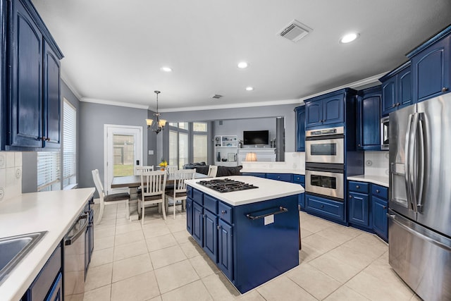 kitchen featuring hanging light fixtures, blue cabinetry, appliances with stainless steel finishes, and tasteful backsplash