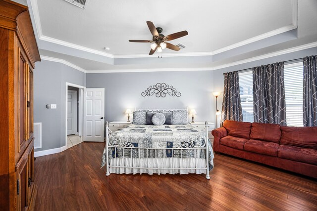 bedroom with a raised ceiling, dark wood-type flooring, ceiling fan, and crown molding