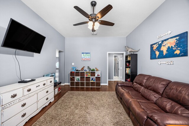 living room featuring dark wood-type flooring and ceiling fan