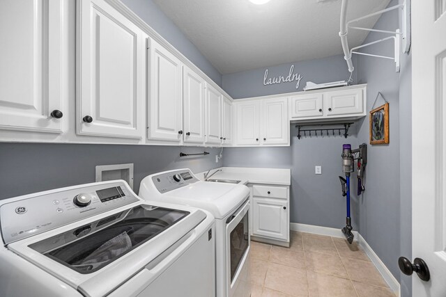 washroom featuring cabinets, light tile patterned floors, sink, and independent washer and dryer