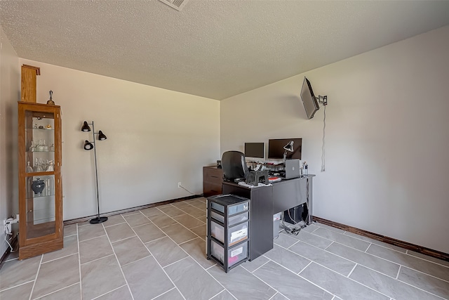 home office with a textured ceiling and light tile patterned flooring