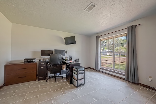 office space with a healthy amount of sunlight, light tile patterned floors, and a textured ceiling