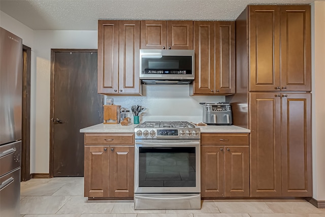 kitchen with stainless steel appliances and a textured ceiling