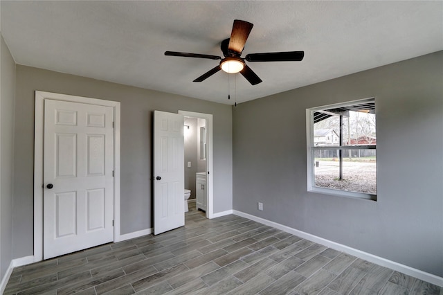 unfurnished bedroom featuring hardwood / wood-style floors, ensuite bathroom, and ceiling fan