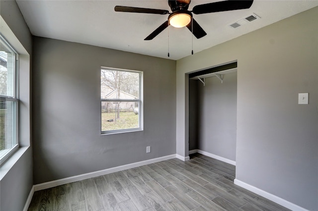 unfurnished bedroom with ceiling fan, light hardwood / wood-style flooring, and a closet