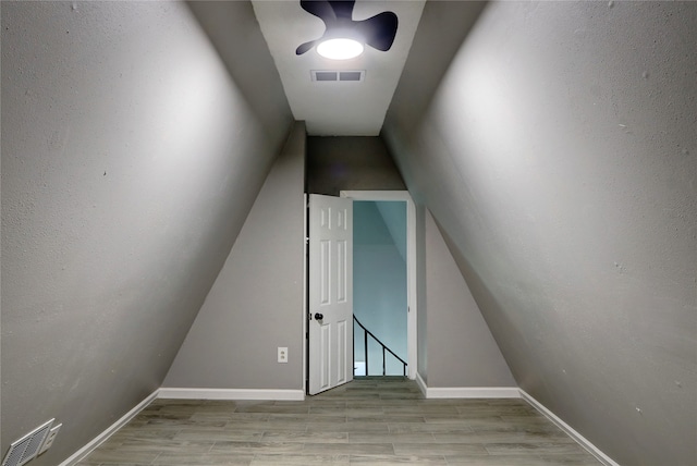 staircase featuring lofted ceiling and hardwood / wood-style floors