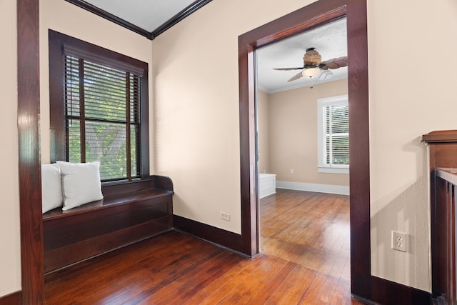 hall featuring ornamental molding, hardwood / wood-style flooring, and a healthy amount of sunlight