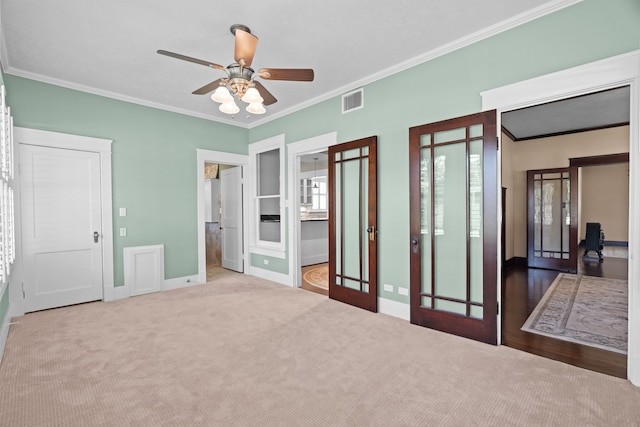 unfurnished bedroom featuring crown molding, ceiling fan, french doors, and carpet