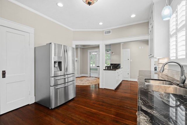 kitchen featuring dark wood-type flooring, ornamental molding, stainless steel refrigerator with ice dispenser, and white cabinetry