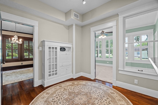 foyer entrance with ceiling fan with notable chandelier and dark hardwood / wood-style flooring