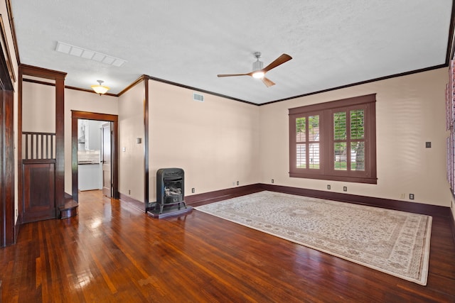 unfurnished living room featuring ceiling fan, dark wood-type flooring, a wood stove, ornamental molding, and a textured ceiling