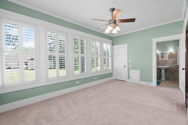 unfurnished bedroom with ornamental molding, ensuite bathroom, ceiling fan, and light carpet