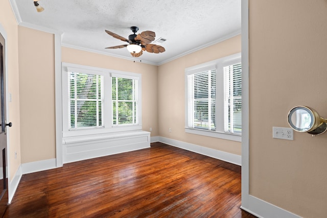 spare room featuring ceiling fan, a wealth of natural light, dark wood-type flooring, and a textured ceiling