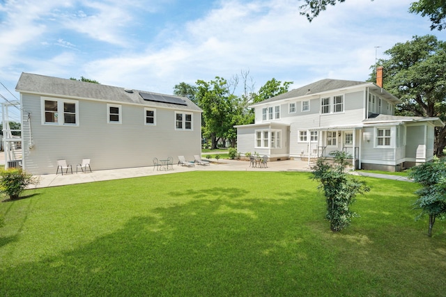 603 Hardeman St, Sealy, TX 77474 - rear view of property with a lawn, a chimney, a patio, and solar panels