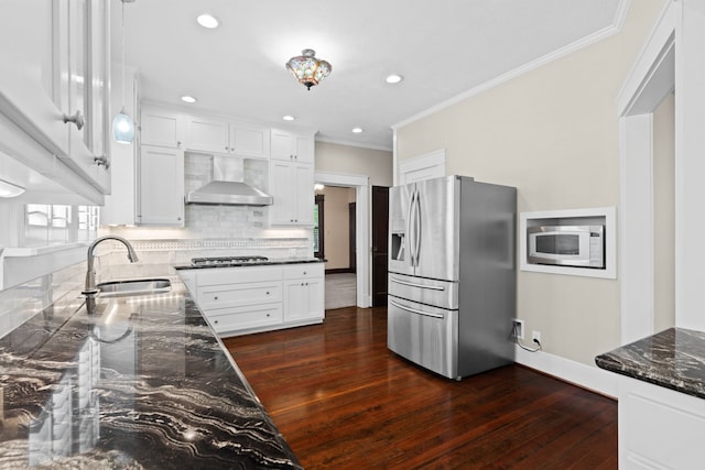 kitchen with wall chimney range hood, sink, stainless steel appliances, dark hardwood / wood-style floors, and white cabinetry