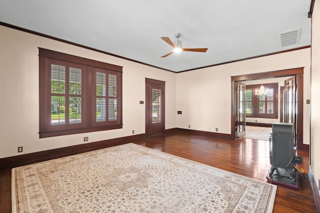 603 Hardeman St, Sealy, TX 77474 - unfurnished living room with visible vents, crown molding, dark wood finished floors, and ceiling fan with notable chandelier