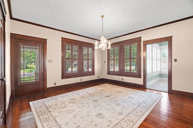 unfurnished dining area featuring an inviting chandelier, plenty of natural light, and dark hardwood / wood-style flooring