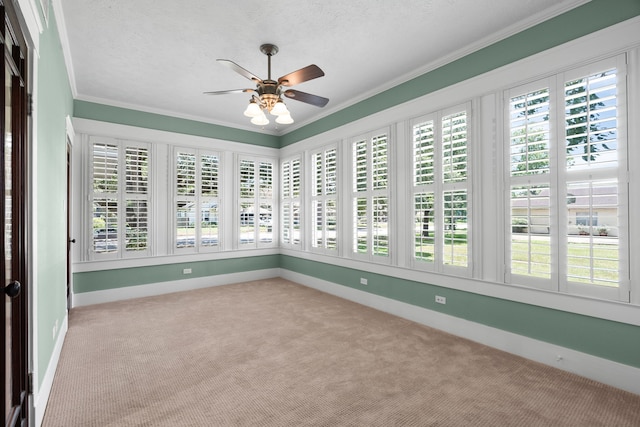 unfurnished sunroom featuring ceiling fan and plenty of natural light