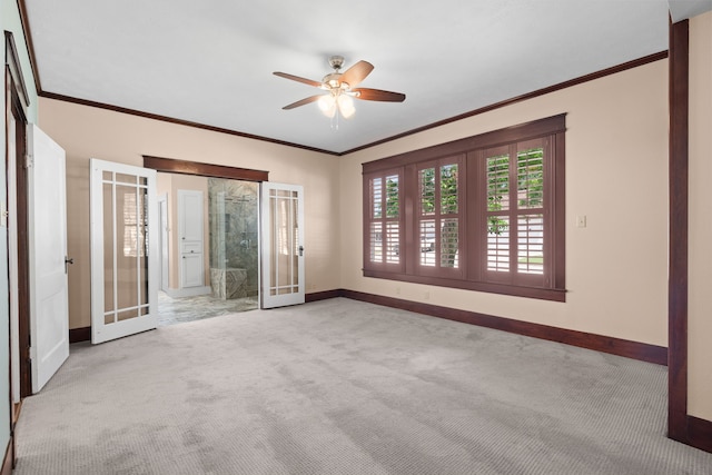 empty room with french doors, light colored carpet, crown molding, and ceiling fan