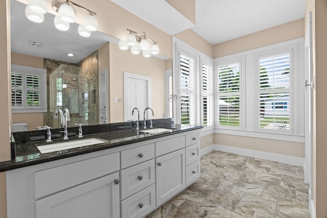 bathroom featuring toilet, vanity, and an enclosed shower