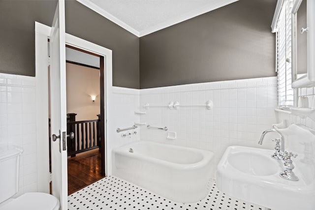 bathroom featuring toilet, a bath, tile walls, crown molding, and hardwood / wood-style floors