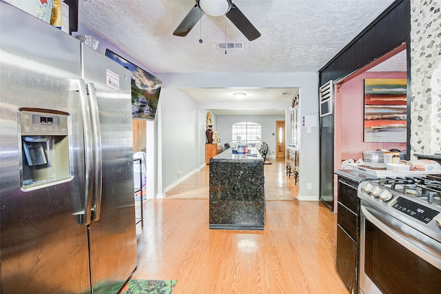 kitchen featuring stainless steel appliances, a textured ceiling, light wood-type flooring, and ceiling fan