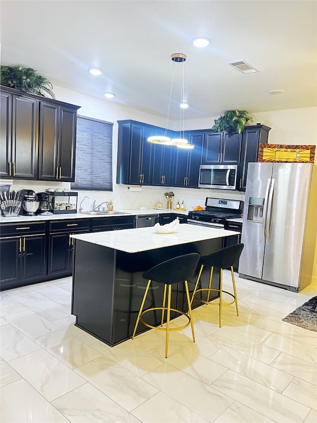 kitchen with a kitchen island, a kitchen breakfast bar, decorative light fixtures, sink, and stainless steel appliances