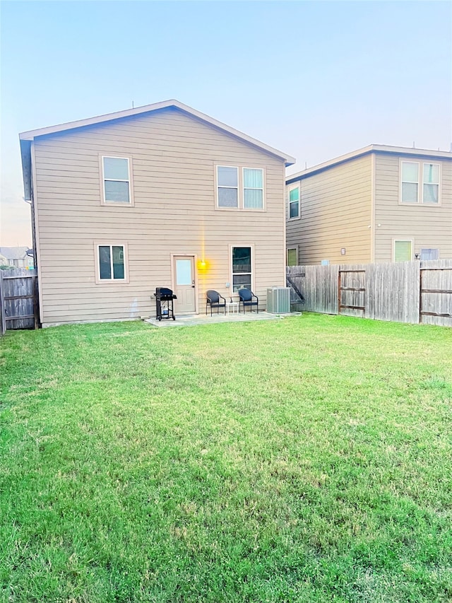 back of house with cooling unit, a lawn, and a patio area