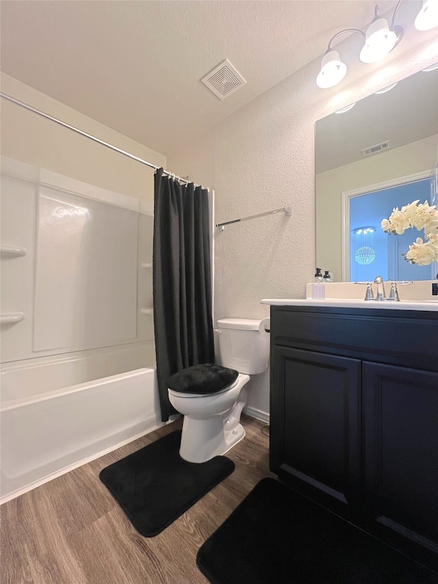 full bathroom featuring shower / bathtub combination with curtain, hardwood / wood-style flooring, vanity, and toilet