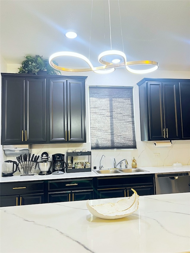 kitchen featuring pendant lighting, dishwasher, light stone countertops, and sink