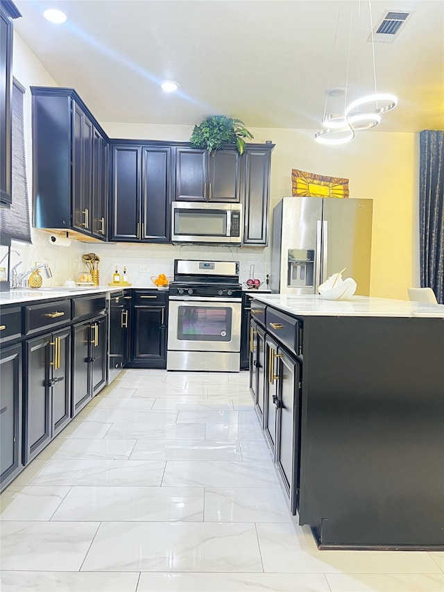 kitchen with decorative light fixtures, appliances with stainless steel finishes, and decorative backsplash