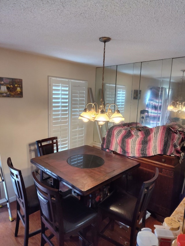 dining space with hardwood / wood-style flooring and a textured ceiling