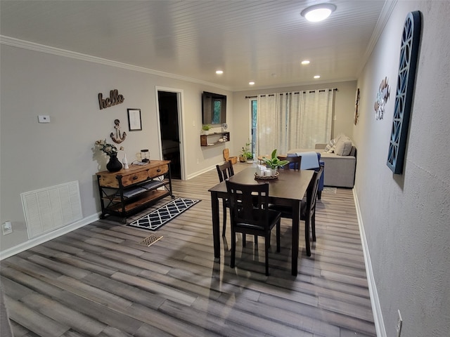 dining area with hardwood / wood-style flooring and crown molding