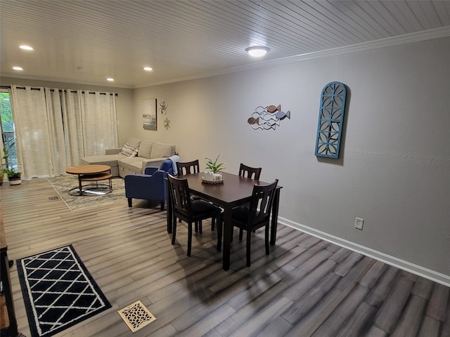 dining space with ornamental molding, hardwood / wood-style flooring, and wood ceiling