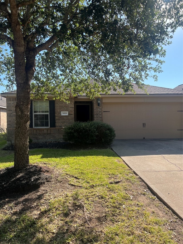 ranch-style home with a garage and a front lawn