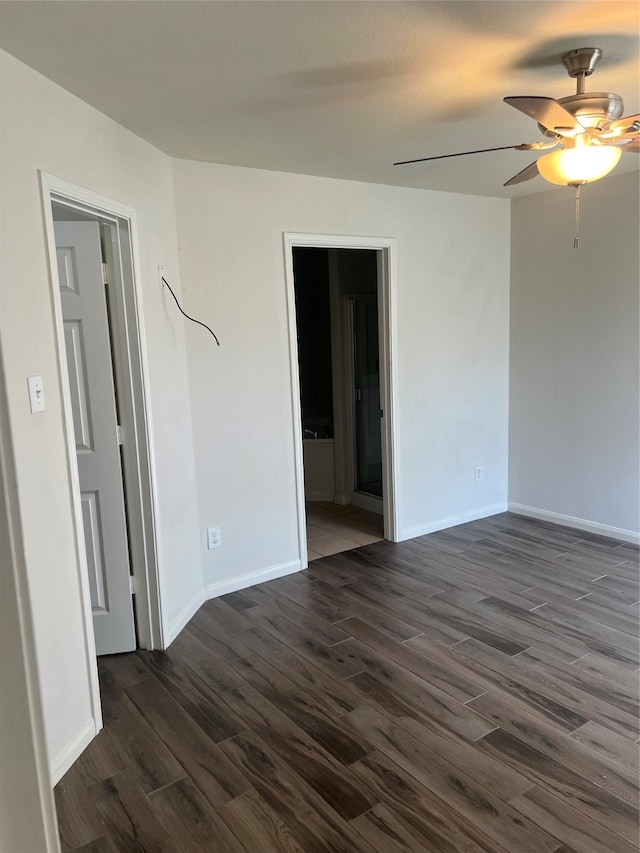 empty room with ceiling fan and dark wood-type flooring