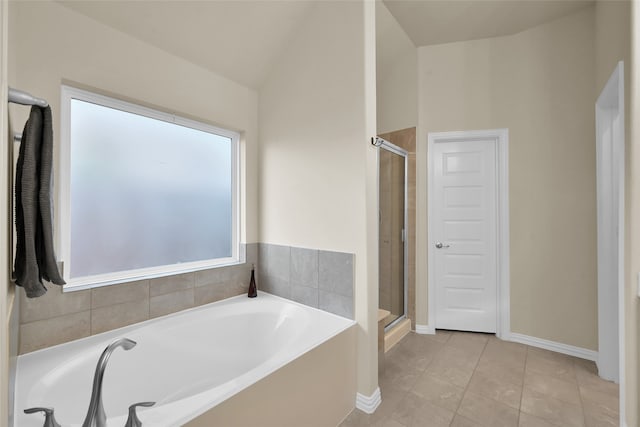 bathroom featuring independent shower and bath, lofted ceiling, and a wealth of natural light