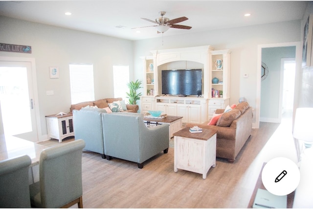 living room with ceiling fan, plenty of natural light, and light hardwood / wood-style floors