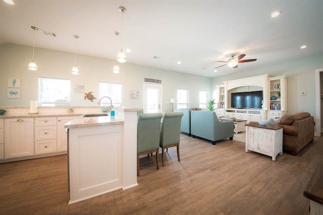 kitchen featuring ceiling fan, white cabinets, dark wood-type flooring, sink, and pendant lighting