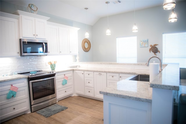 kitchen with white cabinets, lofted ceiling, hanging light fixtures, sink, and stainless steel appliances