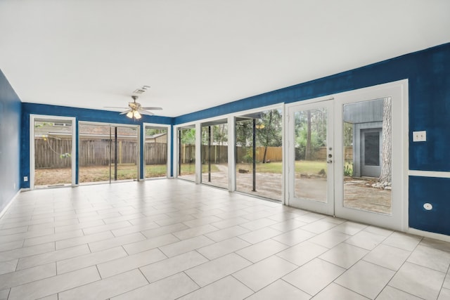 unfurnished sunroom with ceiling fan