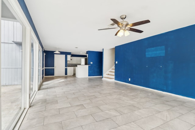 unfurnished living room featuring light tile patterned floors and ceiling fan