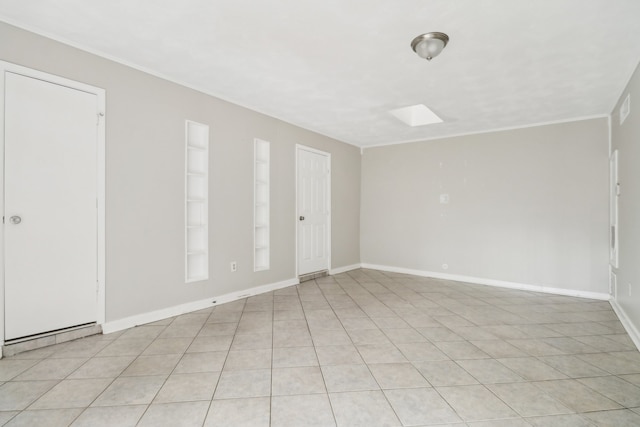 unfurnished room with light tile patterned flooring and a skylight