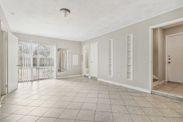 spare room featuring light tile patterned flooring and built in features