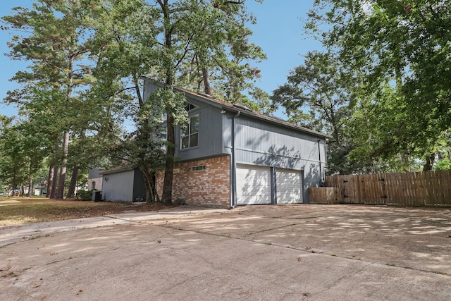 view of side of home with central AC unit and a garage