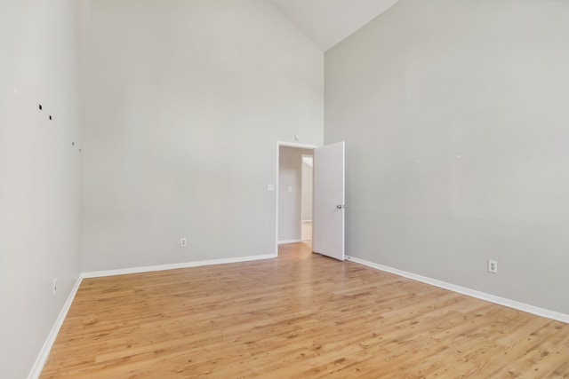 unfurnished room featuring light hardwood / wood-style flooring and high vaulted ceiling