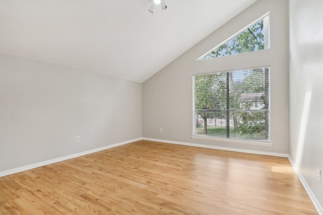 interior space with high vaulted ceiling, plenty of natural light, and light hardwood / wood-style floors