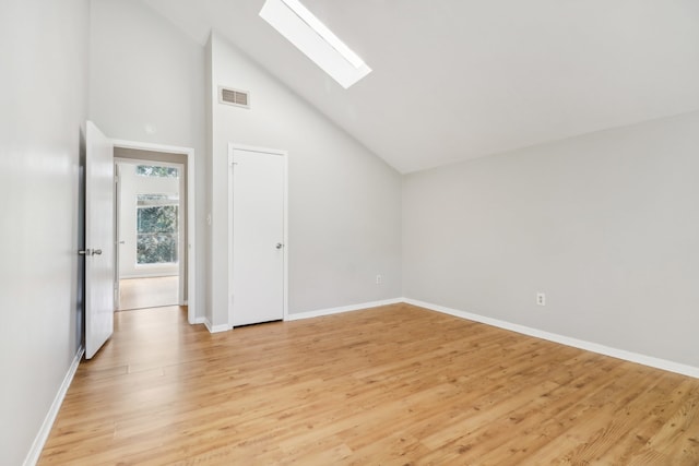 additional living space featuring a skylight, light hardwood / wood-style floors, and high vaulted ceiling